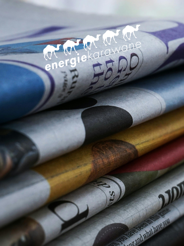 Energiekarawanenlogo auf Zeitungsstapel
